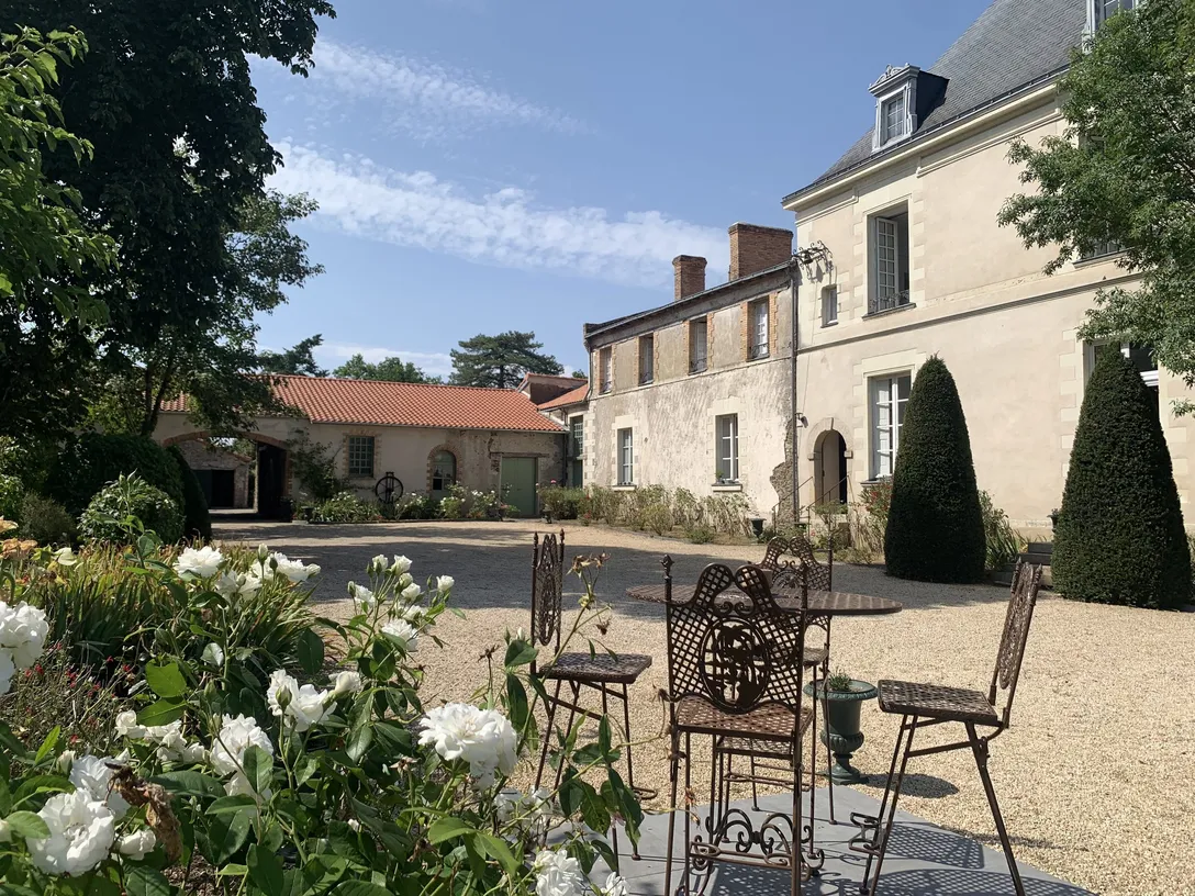 Table et chaises en fer forgé dans la cour fleurie du château