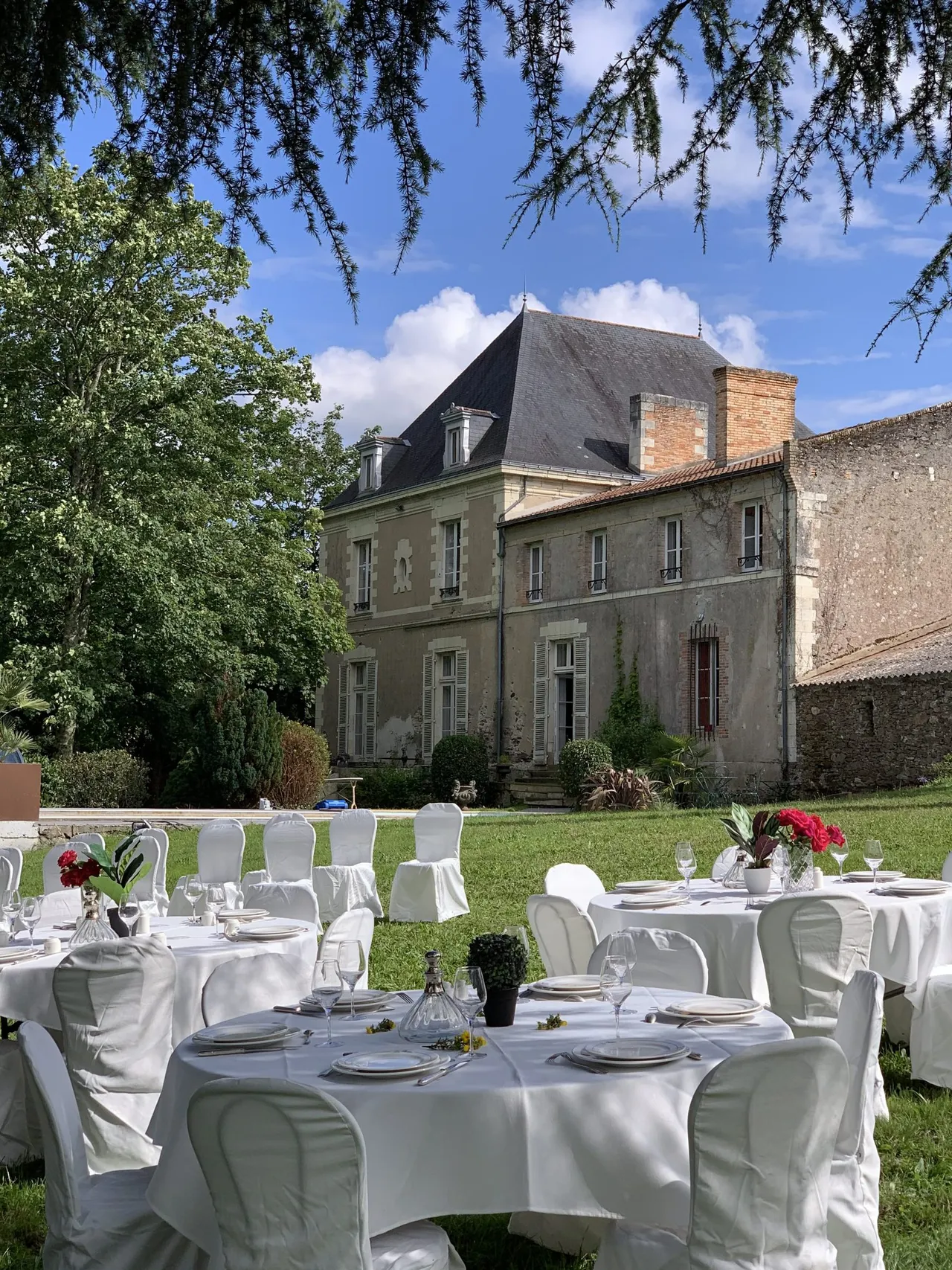 Tables de réception dressées dans le parc devant la façade du château