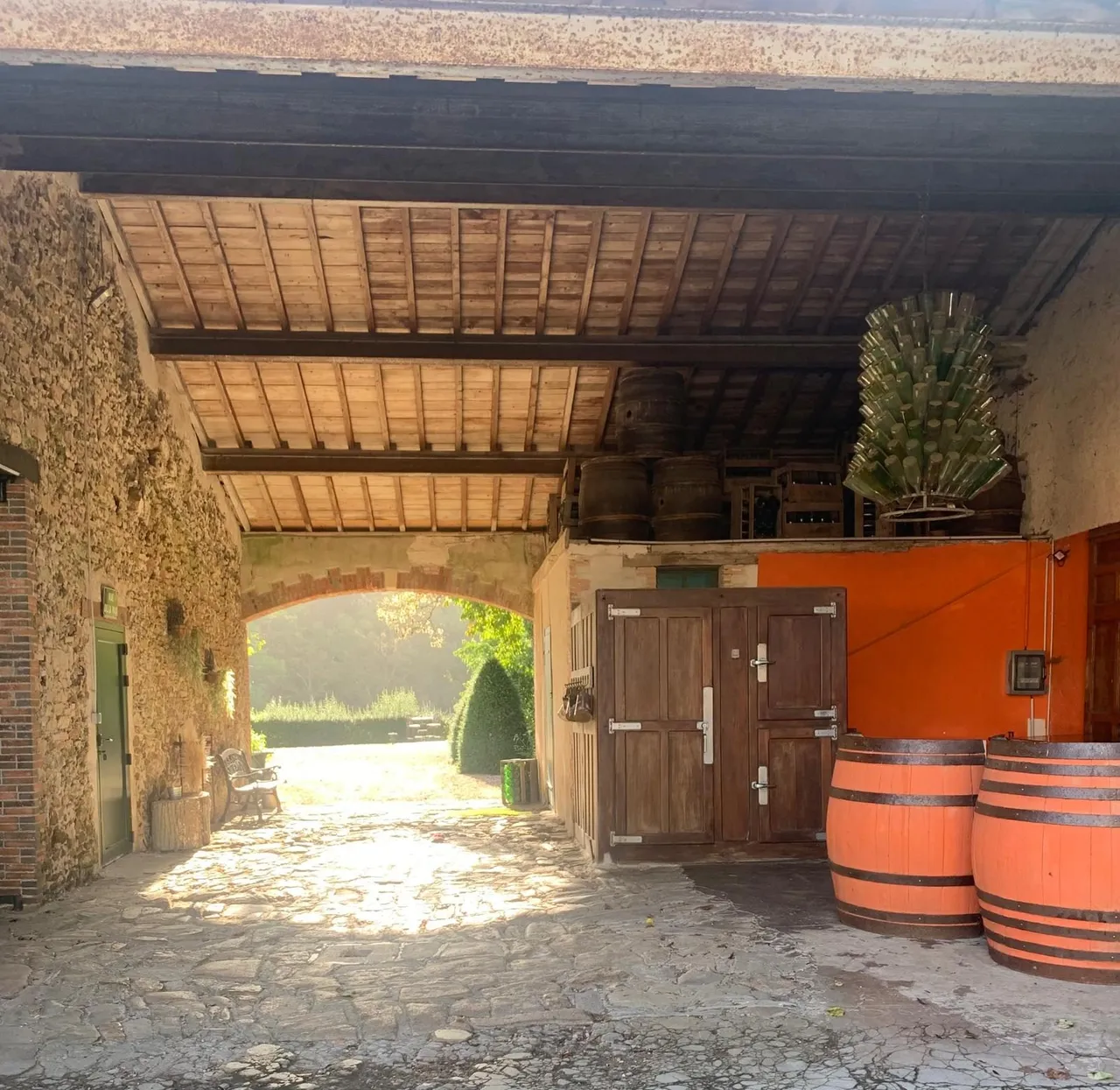 Porche voûté du château avec tonneaux et portes en bois