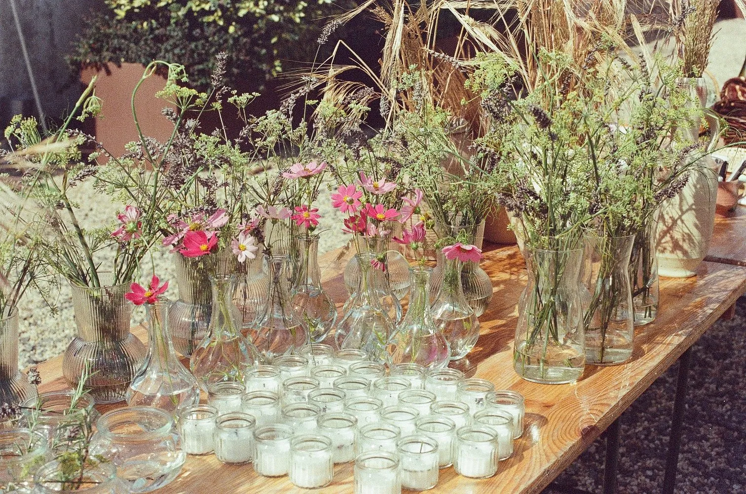 Bouquets de fleurs des champs et photophores sur une table en bois