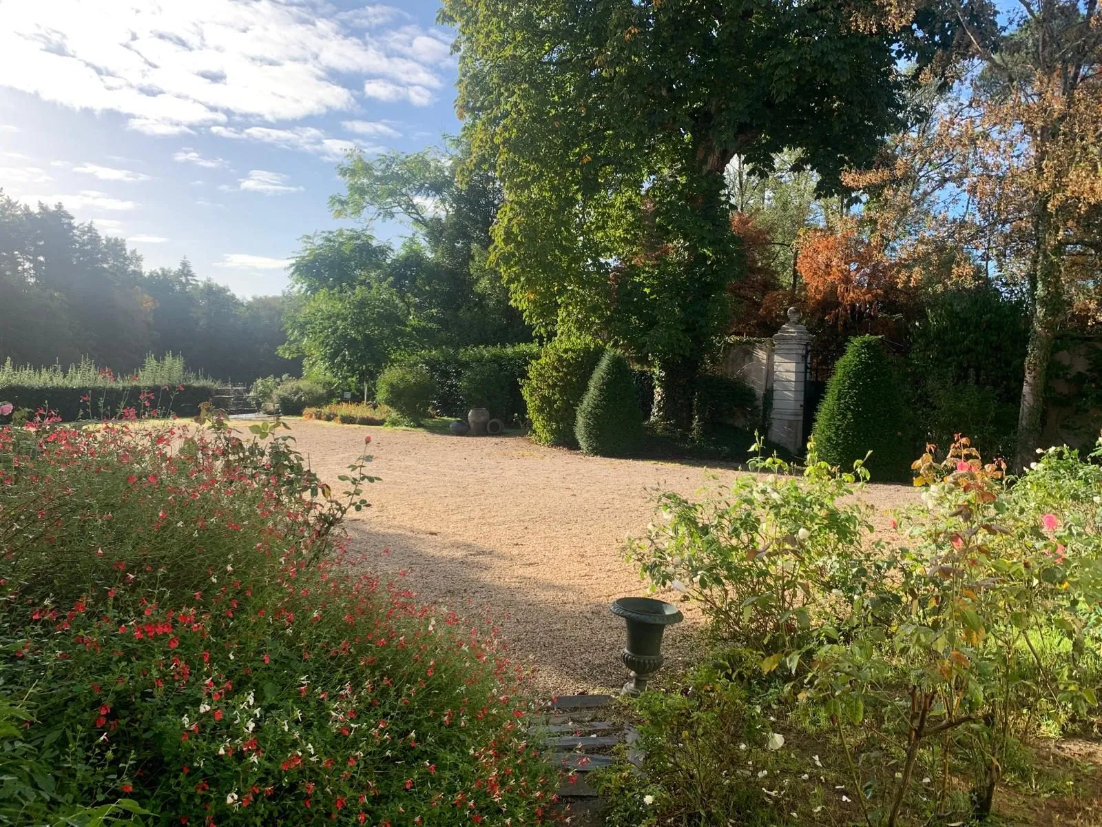 Allée de gravier bordée de fleurs menant au château