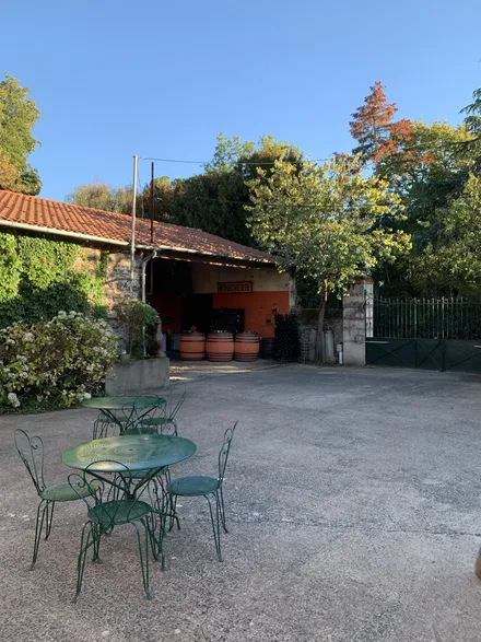 Terrasse ombragée avec tables de jardin près des dépendances