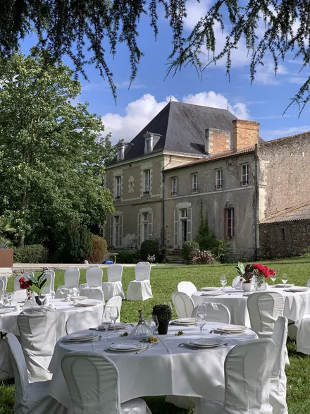Tables de réception dressées dans le parc devant la façade du château