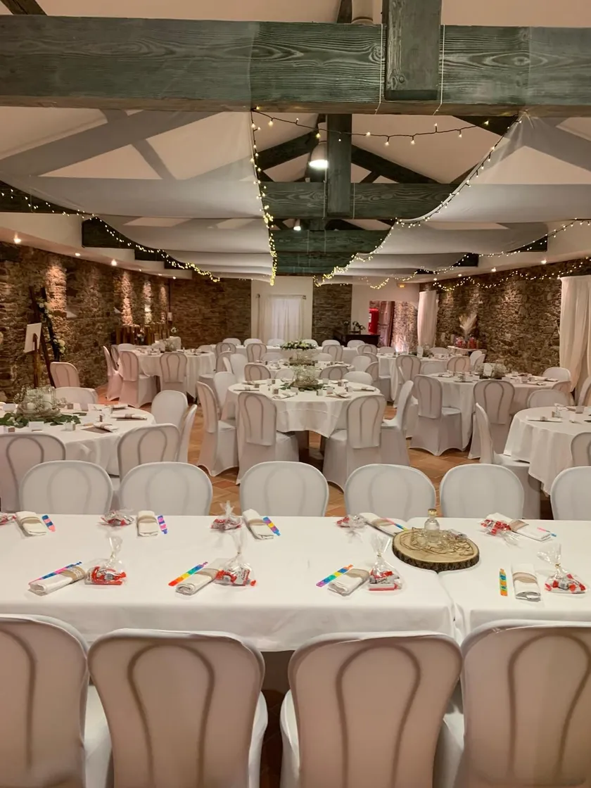 Salle de réception sous des voilages et guirlandes lumineuses